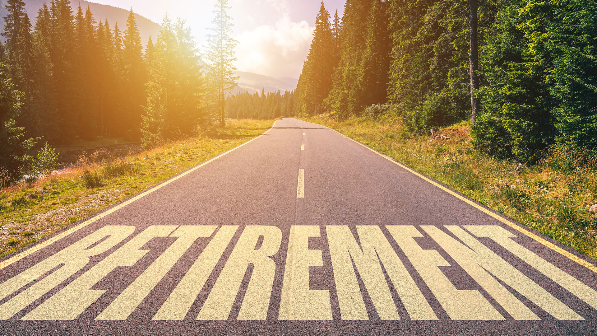 A tree lined road with the word “retirement” painted across it.