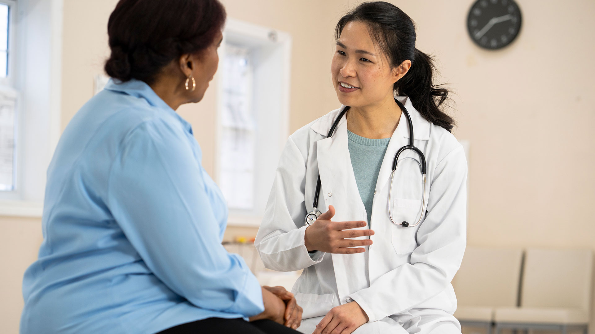 A doctor and a patient sit and talk.