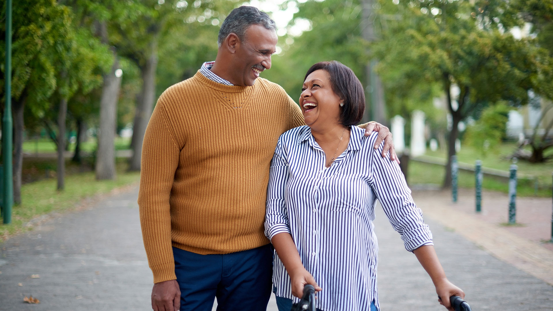 Two people walk down a path and embrace.