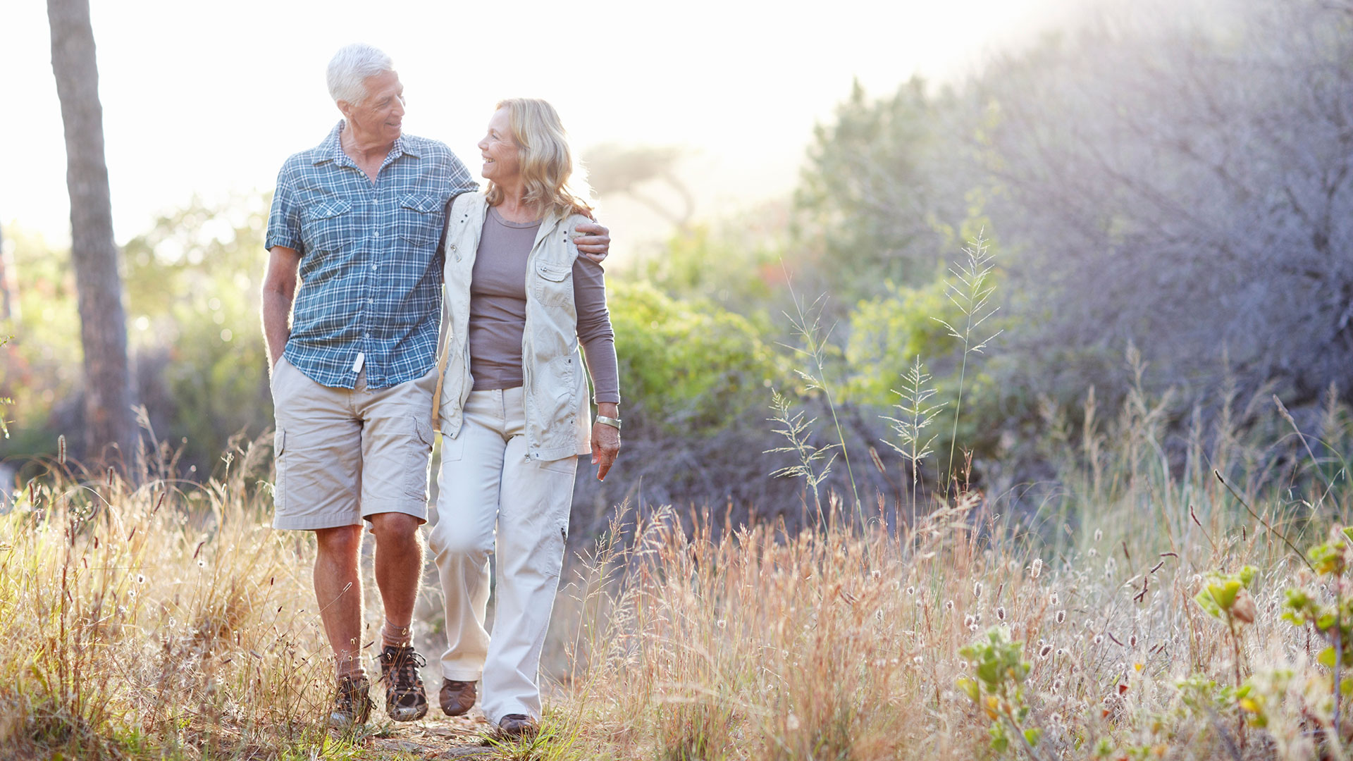 Two people walk down a path and embrace.