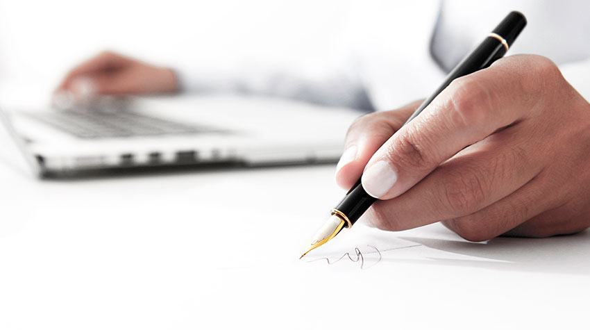 Photo of a woman's hand writing on a piece of paper.